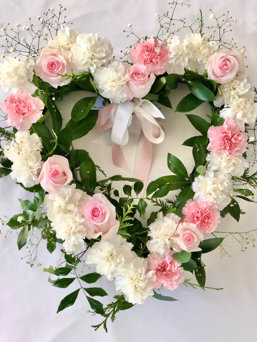 Heart shaped memorial wreath with pink roses and white stocks