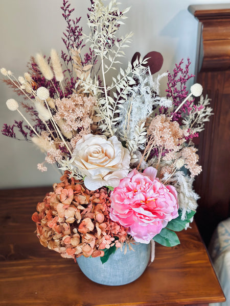 Vibrant silk and dry flower arrangement in a ceramic vase