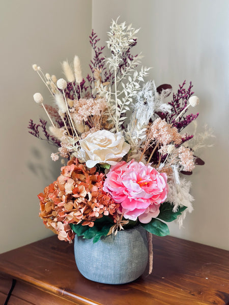 Vibrant silk and dry flower arrangement in a ceramic vase