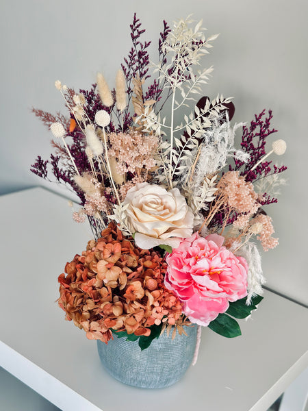 Vibrant silk and dry flower arrangement in a ceramic vase